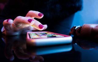 person using black smartphone with gray and pink case